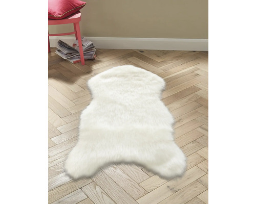 Bílý koberec ve tvaru zvířete na dřevěné podlaze