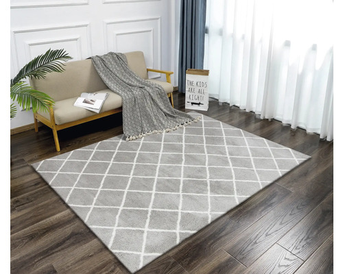 Obývací pokoj s kobercem s kosočtvercovým vzorem, pohovkou a závěsy