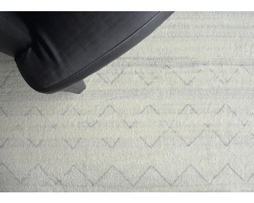 Koberec se vzorem cikcak a noha židle