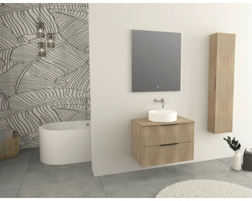 Koupelna s umyvadlem, zrcadlem, vysokou skříní a vanou před tapetou s listovým vzorem