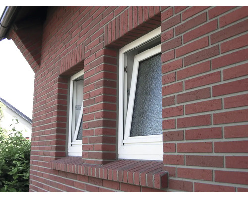 Vnější pohled na dům se dvěma vyklopenými okny a fasádou z červených cihel