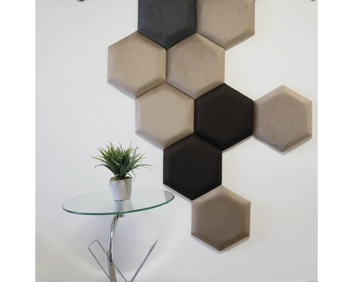 Dekorativní šestihranné nástěnné panely v různých barvách na zdi, vedle malého stolku s rostlinou.