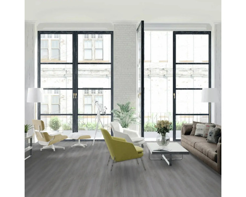 Světlá obývací místnost s šedou podlahou, pohovkou, křesly a okny