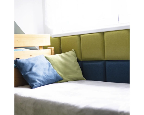 Detailní pohled na postel s čalouněným čelem, zdobenou polštáři