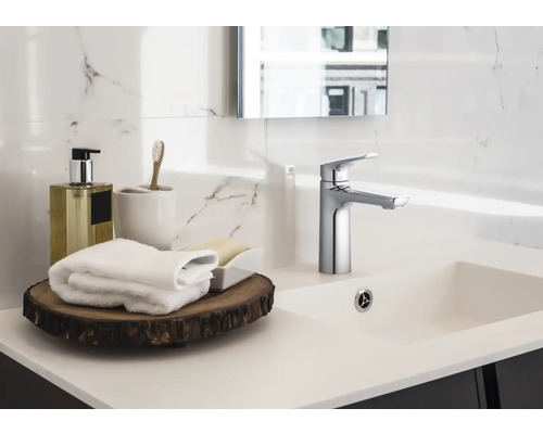 Umyvadlo v koupelně s baterií, ručníky a koupelnové doplňky