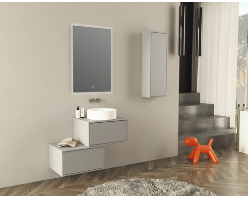 Moderní koupelna s umyvadlem, zrcadlem, závěsnou skříňkou a dekorativními prvky.