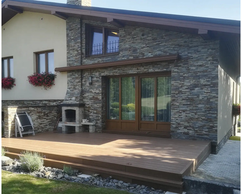 Pohled na dům s terasou, kamennou fasádou a zděným venkovním grilem