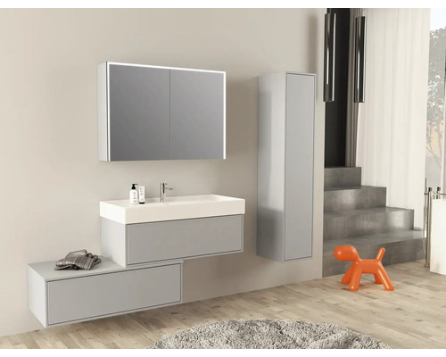 Moderní koupelna s umyvadlem, zrcadlová skříňka s osvětlením a vysoká skříňka.