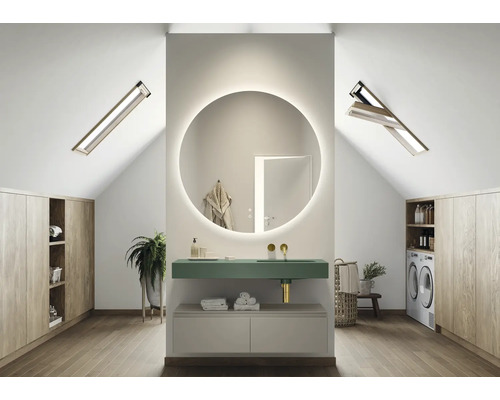 Moderní koupelna v podkroví s kulatým zrcadlem, umyvadlem, pračkou a dřevěnými skříněmi