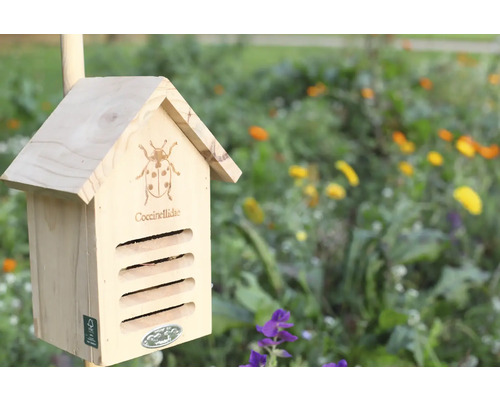 Dřevěný domeček pro berušky na zahradě