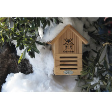 Dřevěný domeček pro berušky s dekorací na zahradě