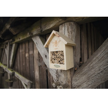 Dřevěný hmyzí hotel s bambusovými trubkami na dřevěném sloupku