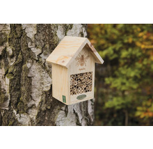 Dřevěný hmyzí hotel na kmeni stromu s trubkami jako hnízdiště