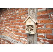 Hmyzí hotel ze dřeva s bambusovými trubkami na cihlové zdi