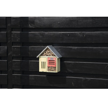 Dřevěný hmyzí hotel na tmavé dřevěné stěně