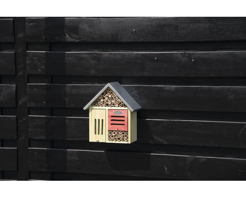 Dřevěný hmyzí hotel na tmavé dřevěné stěně