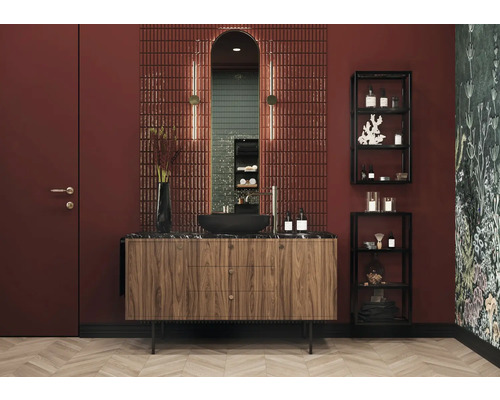 Koupelna s umyvadlem, zrcadlem, obklady a regály na koupelnové potřeby.