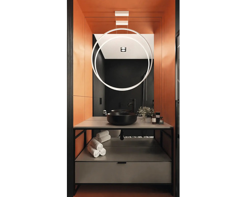 Moderní koupelna s černým umyvadlem, ručníky a kruhovou lampou