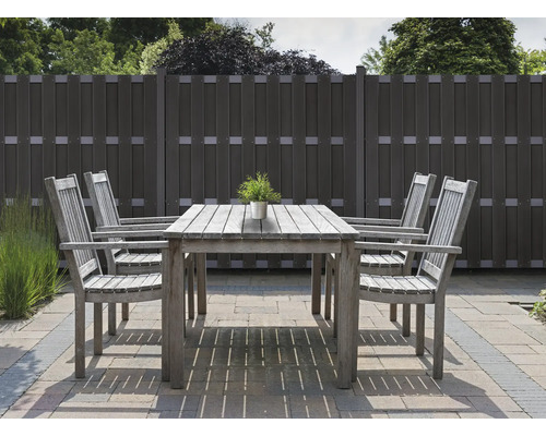 Zahradní scéna s dřevěným stolem, židlemi a plotem