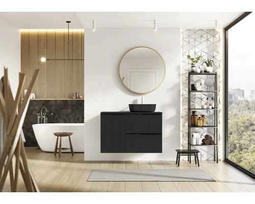 Moderní koupelna s černou umyvadlovou skříňkou, zrcadlem, vanou a regálem.