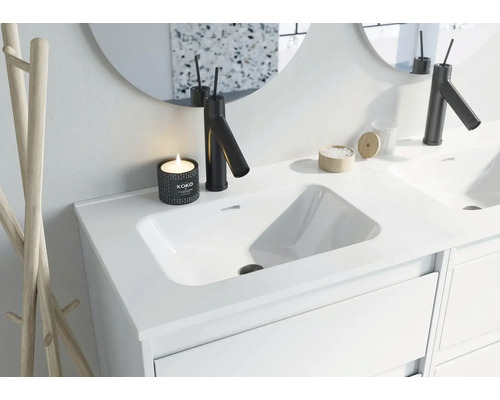 Moderní koupelnové umyvadlo s baterií, zrcadlem a dekorací.