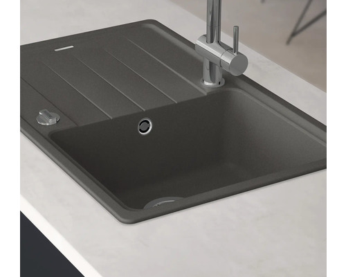 Dřez z kamenného materiálu s odkapávací plochou a armaturou