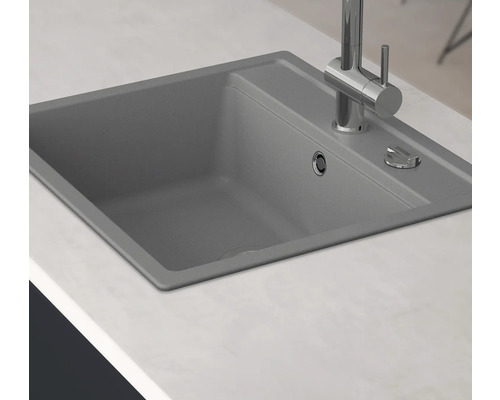 Dřez s vodovodní baterií na kuchyňské lince.