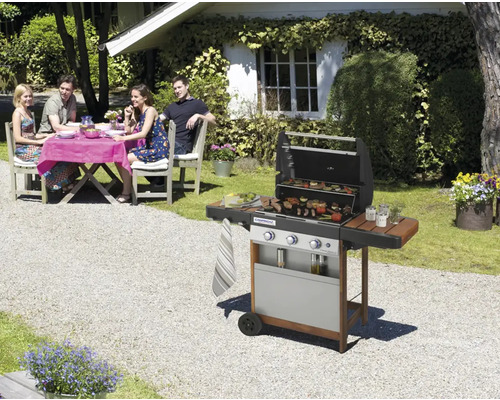 Scéna s plynovým grilem na zahradě a skupinou lidí u stolu