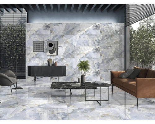 Obývací pokoj s obklady stěn a podlah v mramorovém vzhledu, doplněný nábytkem a dekoracemi.