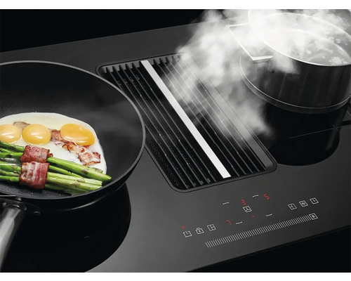 Černý odsavač par s pánví, chřestem, vejci a slaninou a hrncem s párou