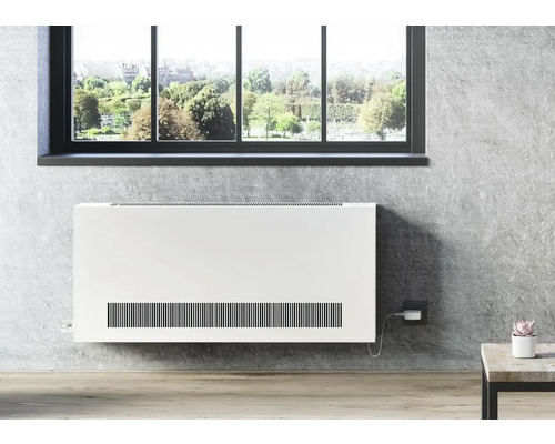 Nástěnný radiátor před oknem v obývacím pokoji.