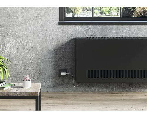 Scéna s radiátorem na betonové stěně pod oknem