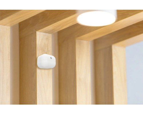 Bílý hlásič kouře na dřevěném stropě