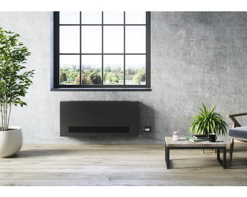 Obývací pokoj s konvektorem pod oknem, stolem a pokojovými rostlinami