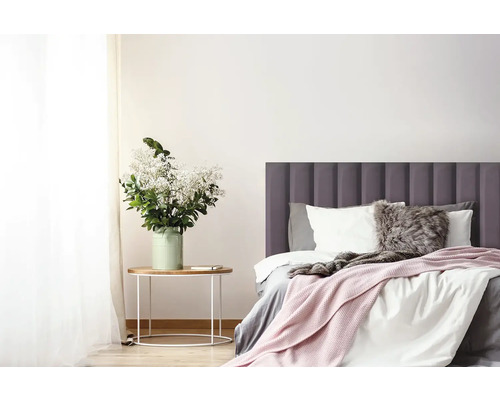 Světlá ložnice s postelí, nočním stolkem a květinami