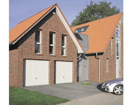 Pohled na dům se dvěma garážovými vraty, cihlovou fasádou a taškovou střechou