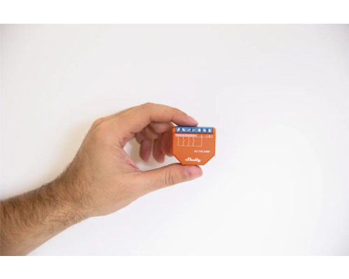 Ruka drží spínač Shelly.