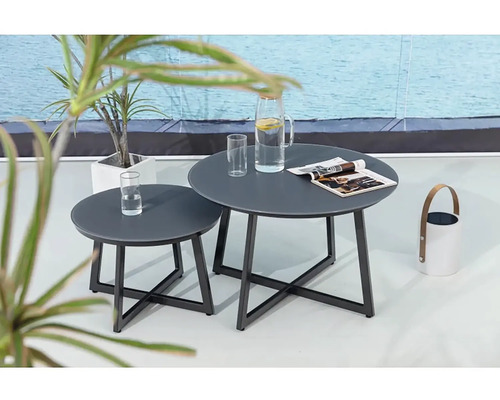 Dva kovové konferenční stolky s kulatými deskami na terase s nápoji a časopisem