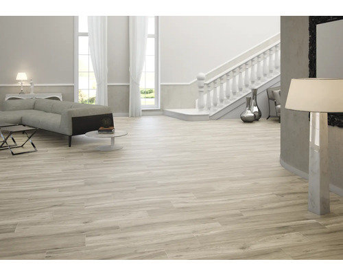 Světlý obývací pokoj s pohovkou, schodištěm a dlaždicemi s dřevěným dekorem