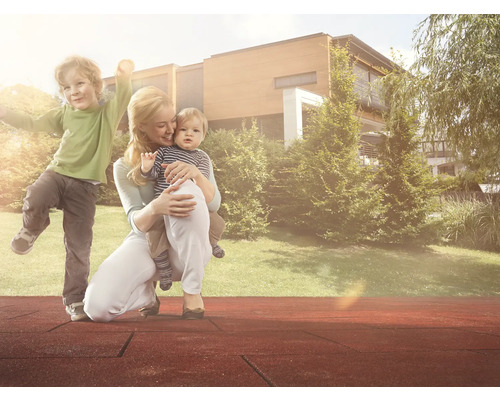 Matka s dětmi na hřišti s bezpečnostními podložkami před domem a zahradou