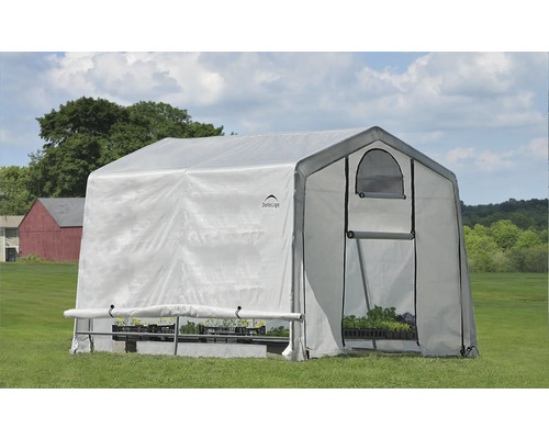 Skleník s rostlinami na louce