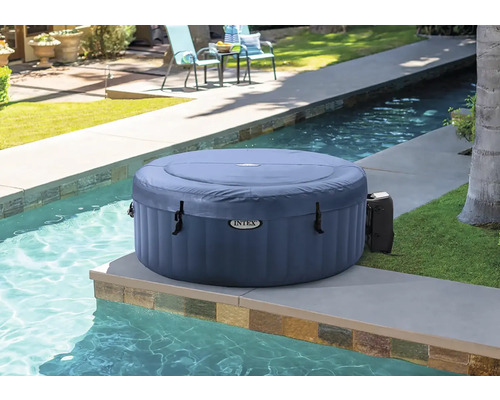 Nafukovací kulatá vířivka Intex vedle bazénu na zahradě.