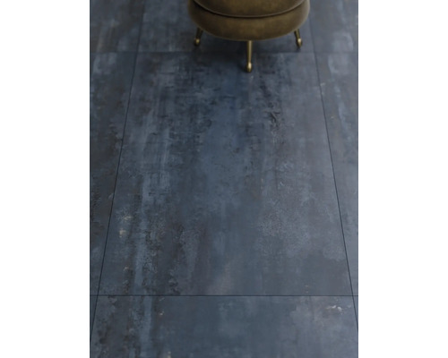 Detailní záběr na podlahové dlaždice s industriálním designem a stoličkou