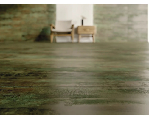 Světlá místnost s podlahovými dlaždicemi imitujícími dřevo, židlí a nočním stolkem