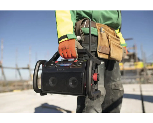 Stavební dělník nese staveništní rádio