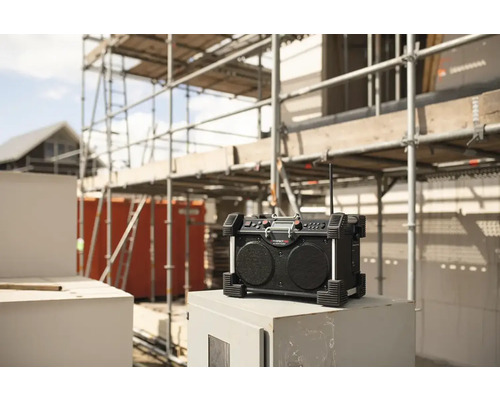 Stavební rádio před nedokončenou budovou s lešením