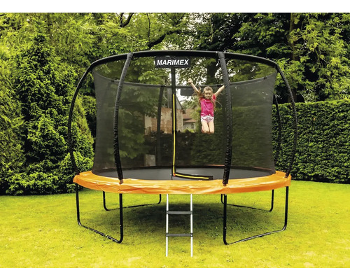 Trampolína Marimex se sítí a žebříkem na zahradě, dítě skáče
