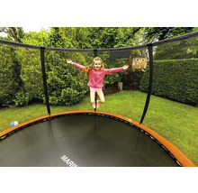 Dívka skáče na zahradní trampolíně se sítí