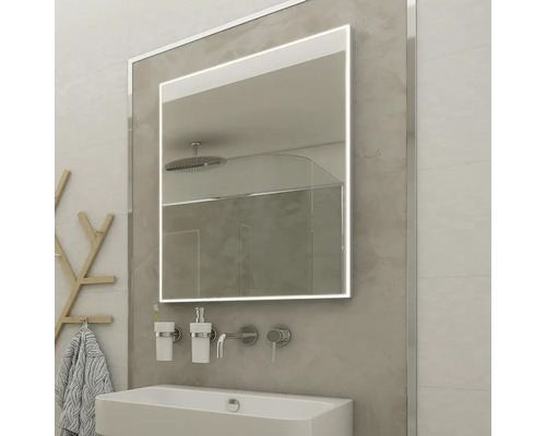 Koupelnová scéna s osvětleným zrcadlem nad umyvadlem