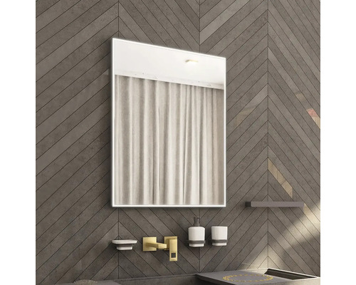 Koupelna s osvětleným zrcadlem nad umyvadlovou baterií